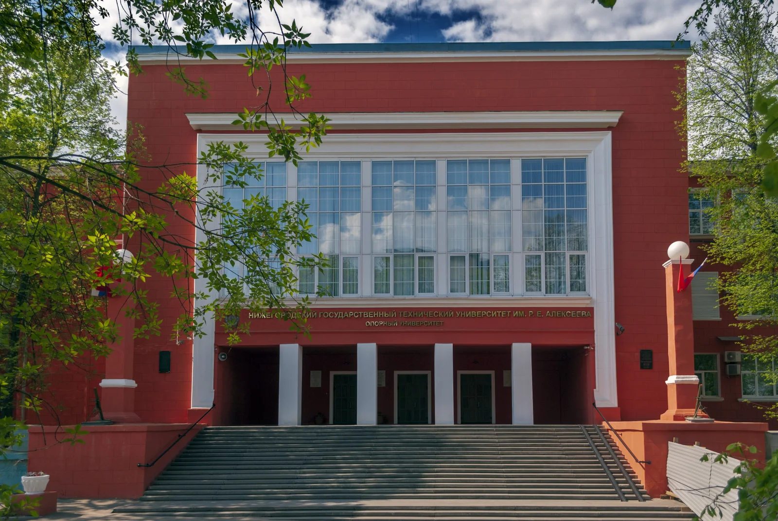 Главный вход первого корпуса НГТУ им. Алексеева в солнечный день под голубым небом