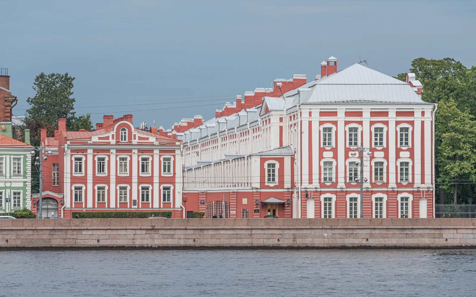 Красный фасад здания Двенадцати коллегий Санкт-Петербургского государственного университета на фоне голубого неба