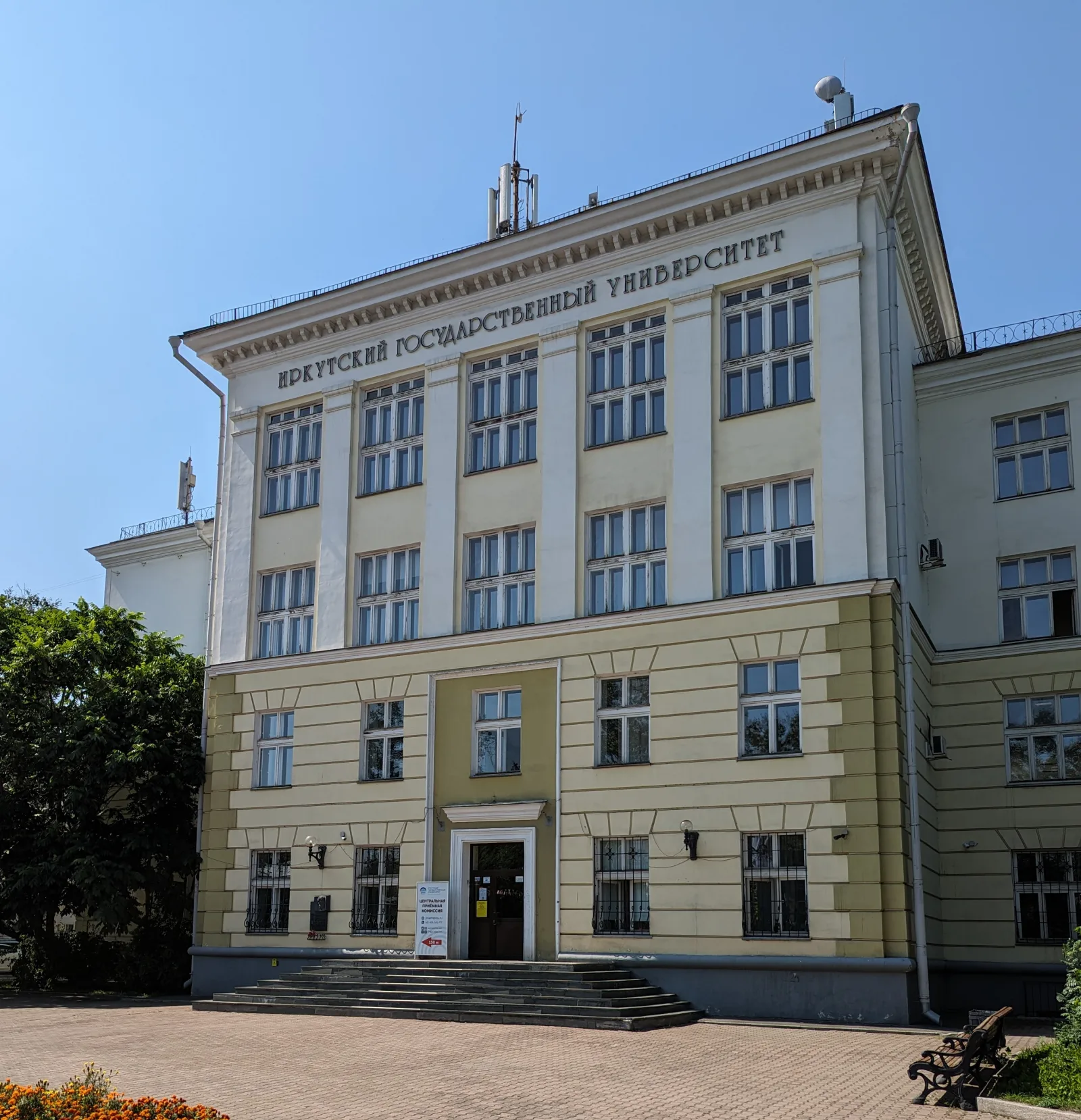 Главный корпус Иркутского государственного университета в солнечный день на фоне ясного голубого неба